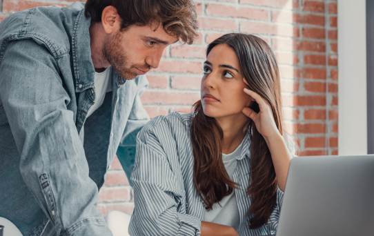 Pessoas analisando problemas de conexão em notebook, representando dificuldades com internet residencial lenta ou instável.