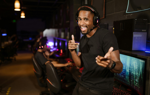 Jogador gamer usando headset e internet de alta velocidade para jogar online em setup de computador gamer