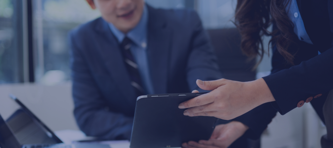 Profissionais analisando dados em tablet durante reunião empresarial sobre infraestrutura de internet corporativa